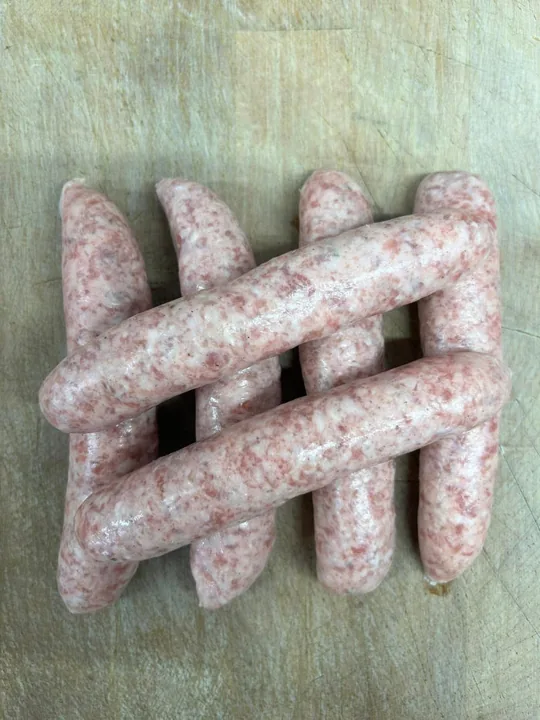 Gluten-free pork sausages arranged on a wooden board